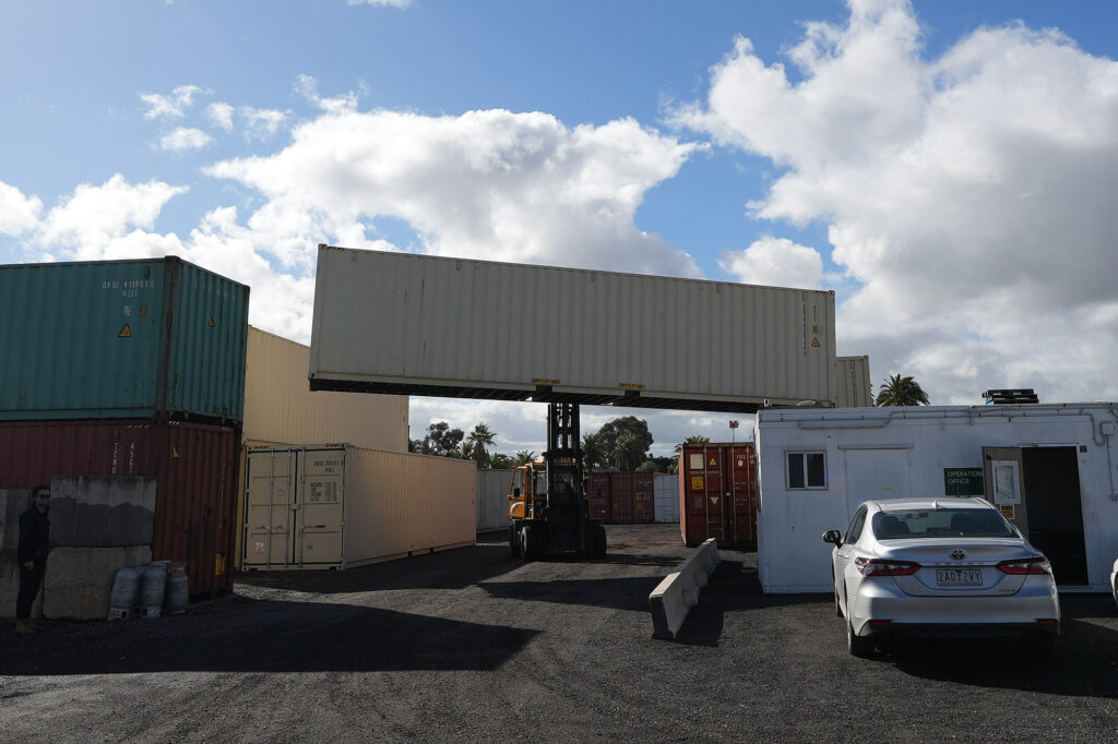 Forklift carrying a shipping container